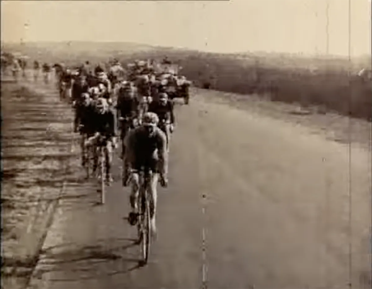 Peloton rijdend door Vlaanderen tijdens de Ronde van Vlaanderen 1923, zwart-wit filmstill
